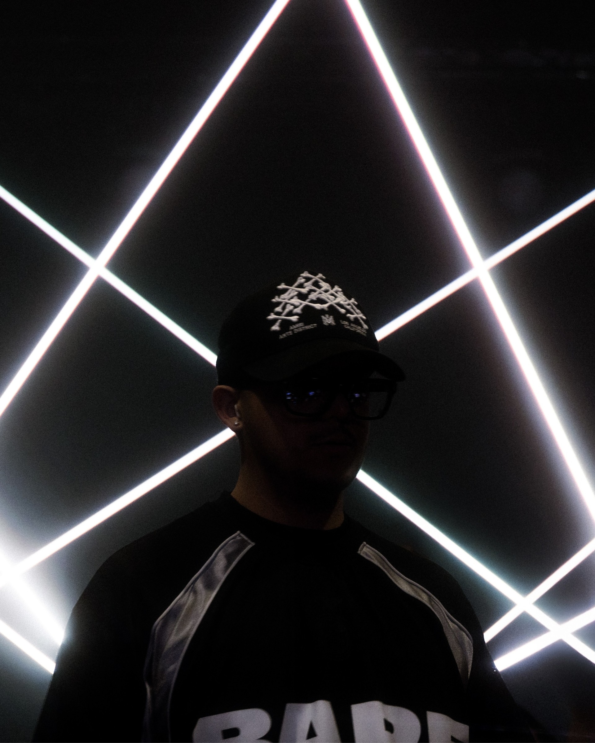 Performer beneath intersecting stage lights