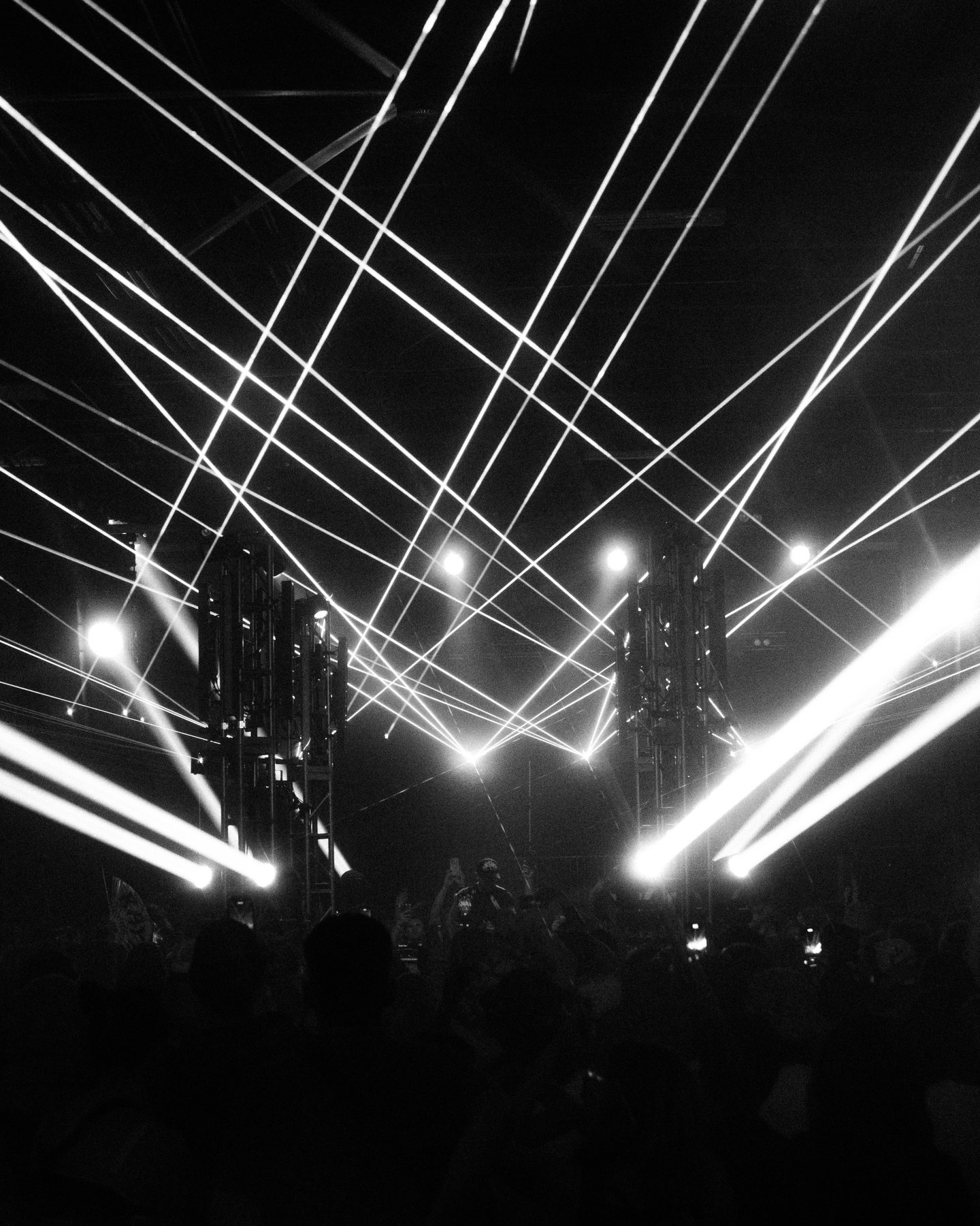 Artist performing with arms raised, pink lasers