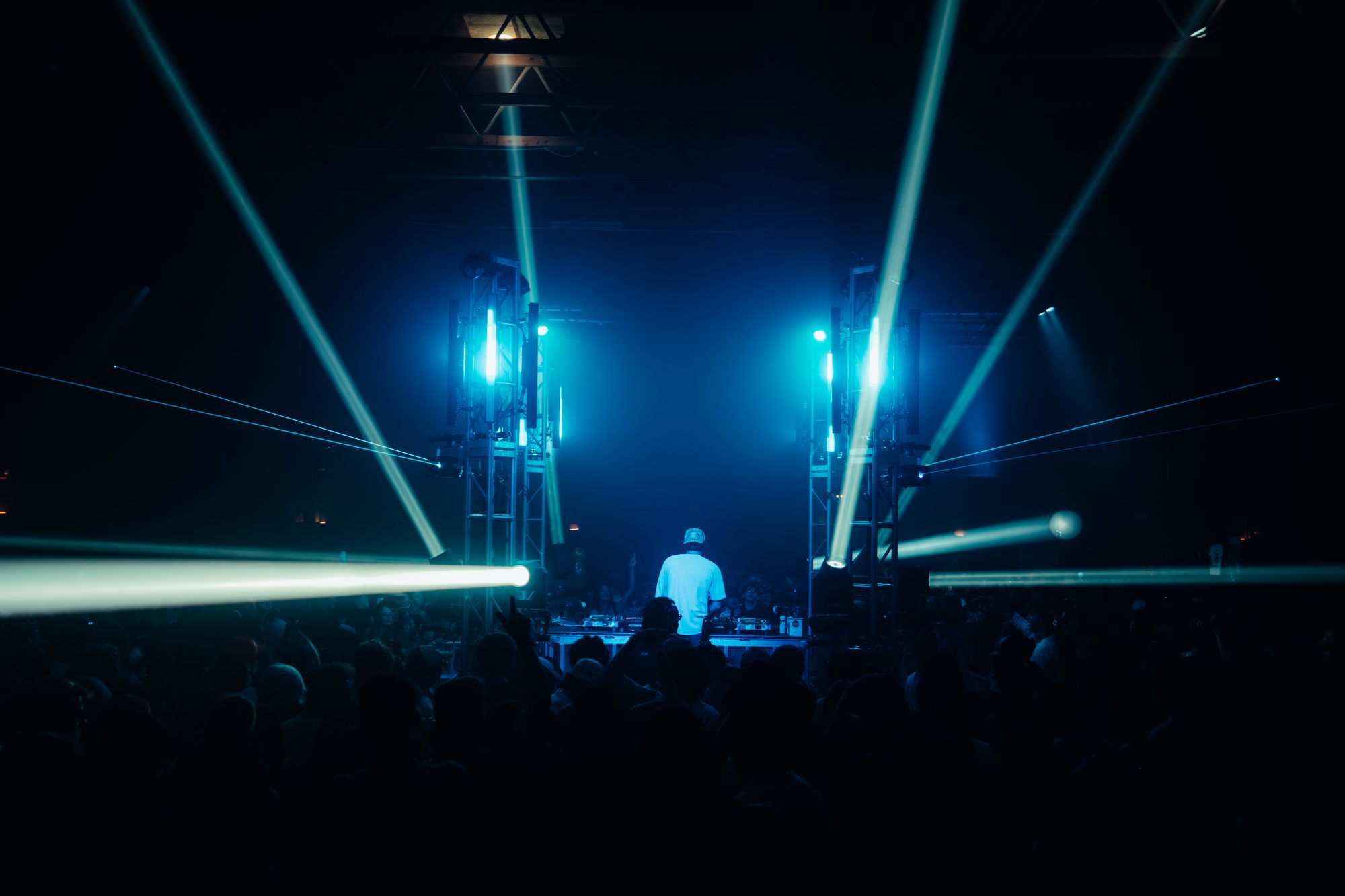 Red and blue stage lights, artist on decks